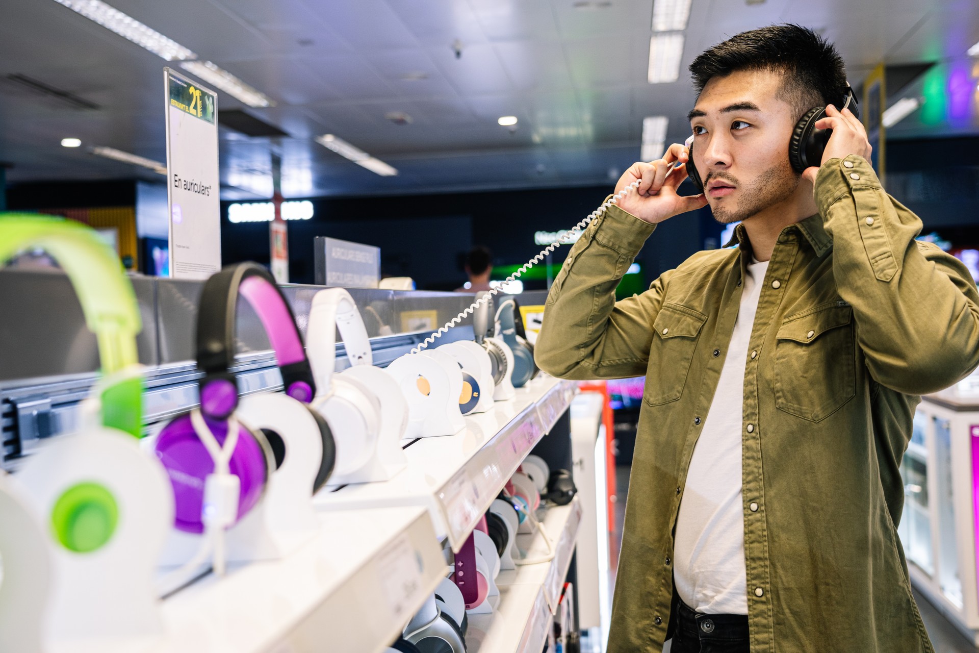 Man Sampling Headphones in Tech Store